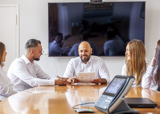 Euroclean Team in einem Besprechungsraum diskutiert Dokumente um einen Tisch mit einem Konferenztelefon.