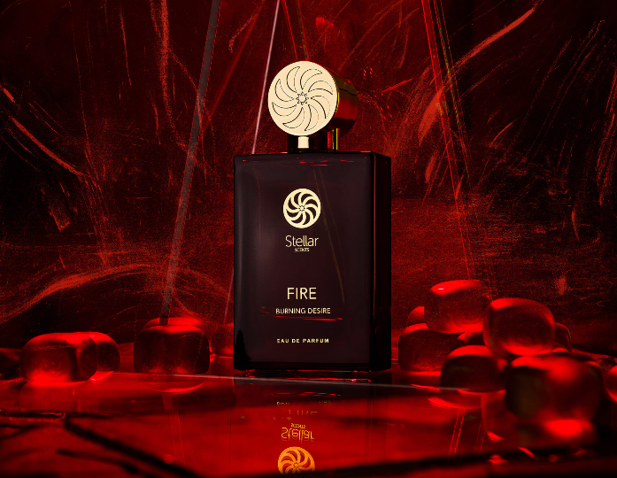 Dark red perfume bottle labeled Stellar Scents FIRE Burning Desire surrounded by red glowing ice cubes with a fiery red background.