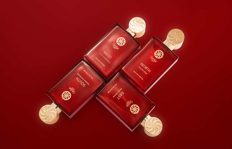 Four red rectangular perfume bottles with gold caps labeled West, North, South, and East arranged in a square on a red background.