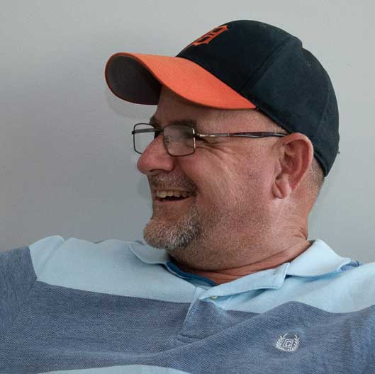 Image of Craig's head with a hat and a happy face