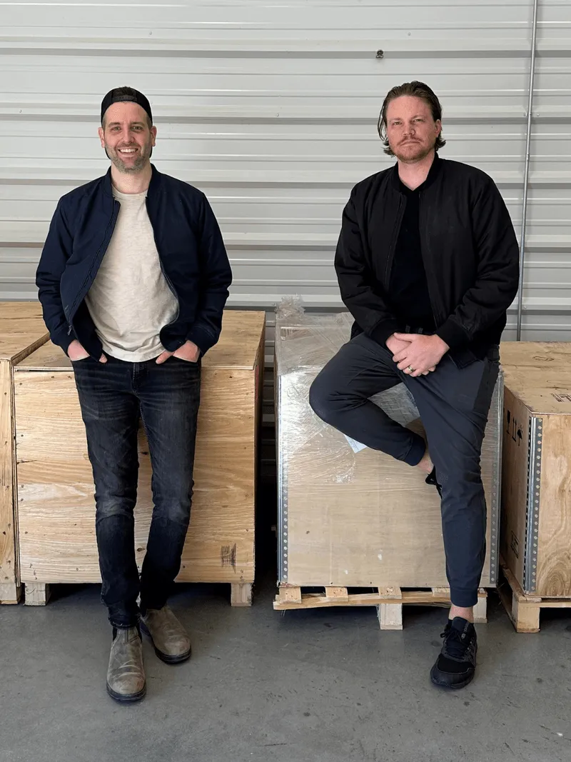Marc and Mark standing in front of a shipping crate