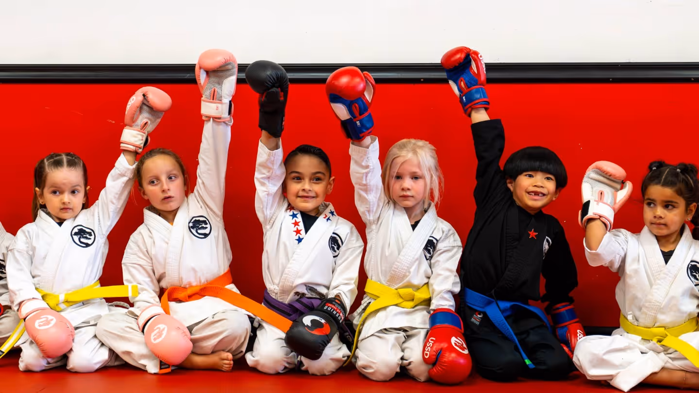 Beginner Karate students stand in a tight row, ready for class to begin.