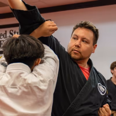 Adults Smile as they hold their karate tournament awards.