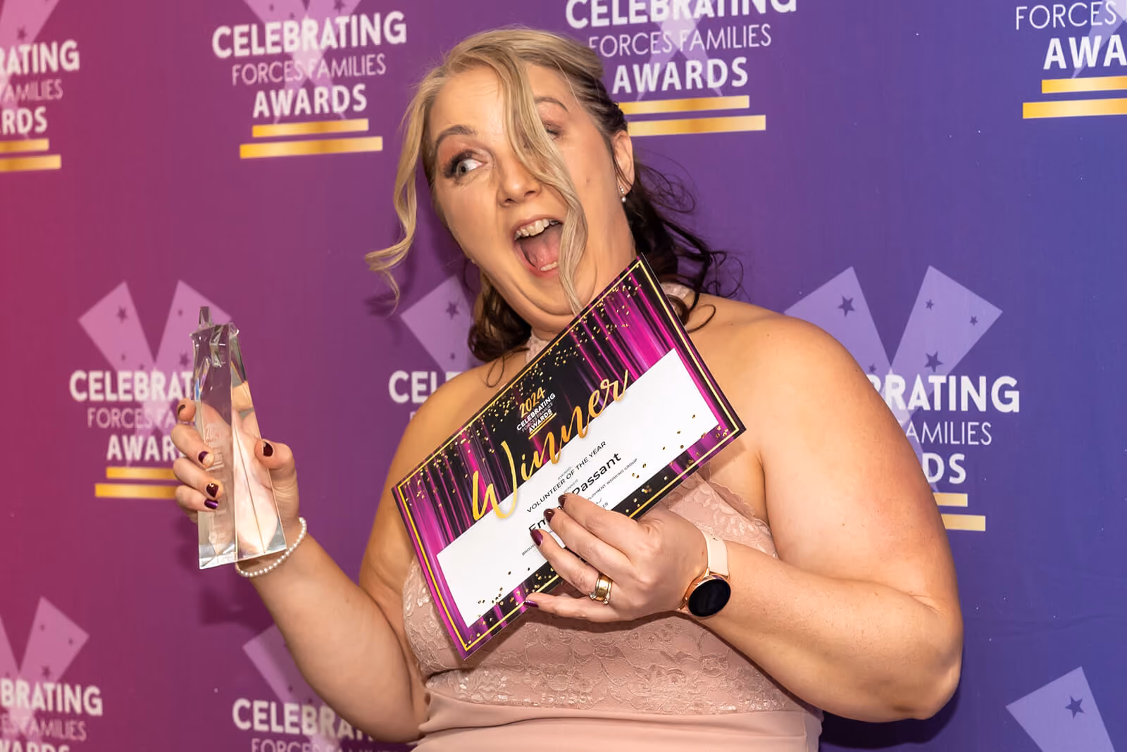 Delighted winner celebrating with trophy and certificate at the Celebrating Forces Families Awards
