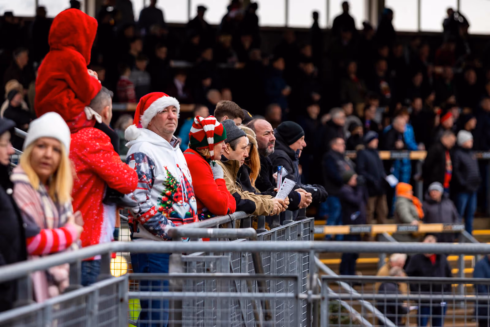 Crowd in festive hats watching from the rail at Carlisle Racecourse — by AlTopping.com