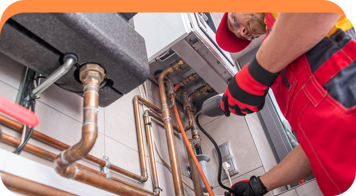 Techniker überprüft mit einem Diagnosetool die Kupferrohre einer Heizungsanlage.