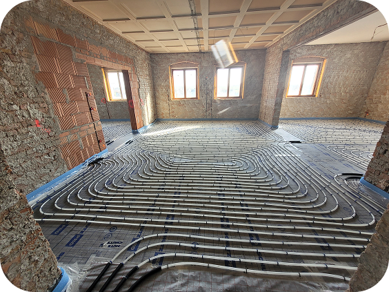 Großer Raum in einem Rohbau mit installierter Fußbodenheizung aus weißen Heizungsrohren auf Unterfolie.