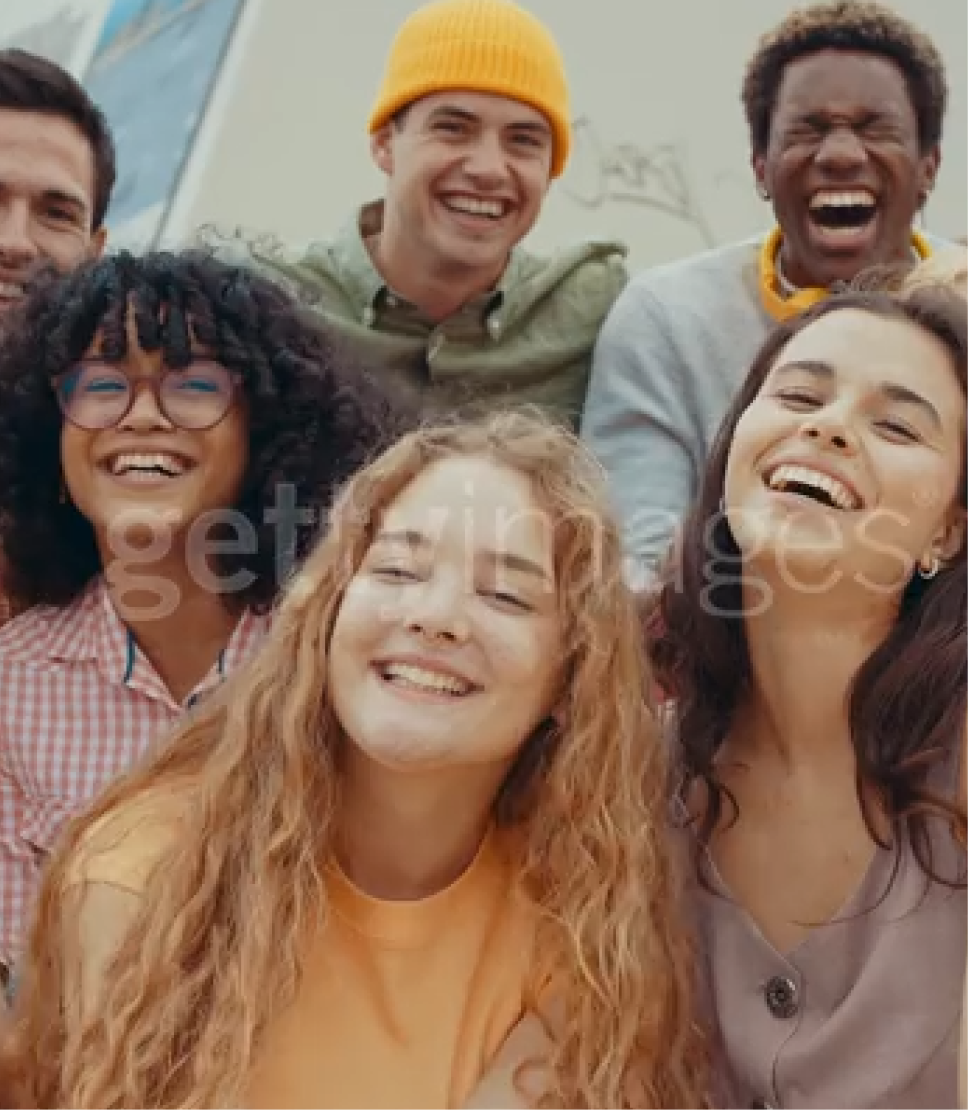 A group of smiling teenagers posing for a photo outdoors.