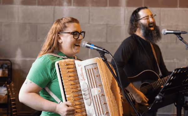 Megan performing accordion and singing
