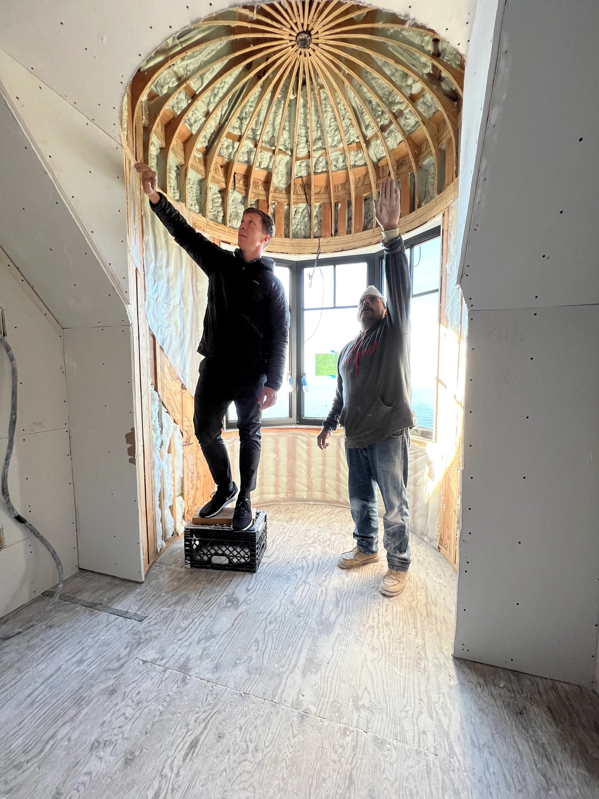 Two drywall installers doing quality control inspection on complex home remodel project