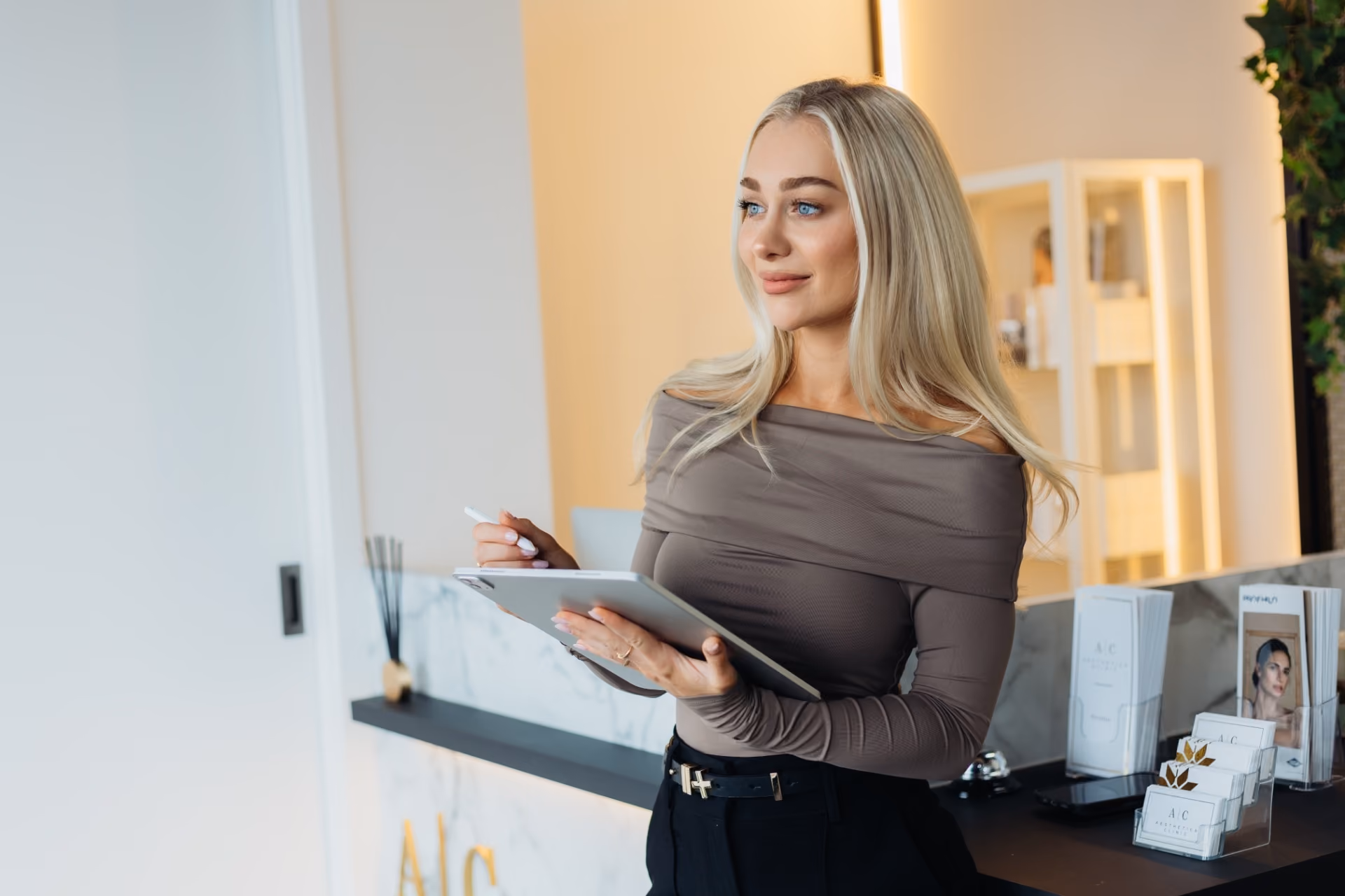 Clinician holding a tablet at the Aesthetica Clinic reception