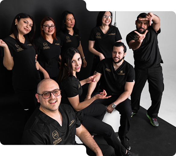 Grupo de ocho profesionales con uniformes negros posando en estudio con fondo blanco y negro.