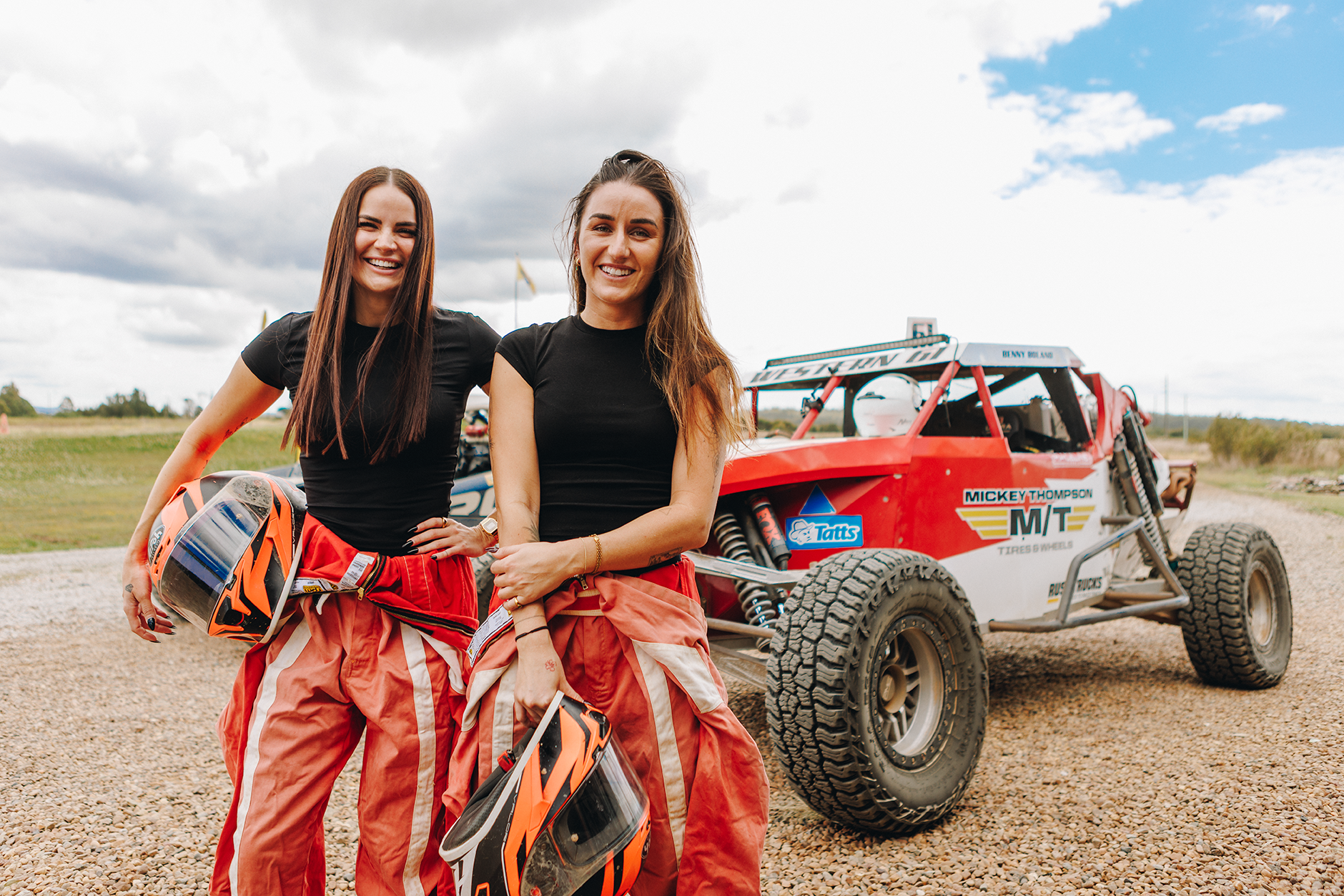 two girls standing in front of racing buggy