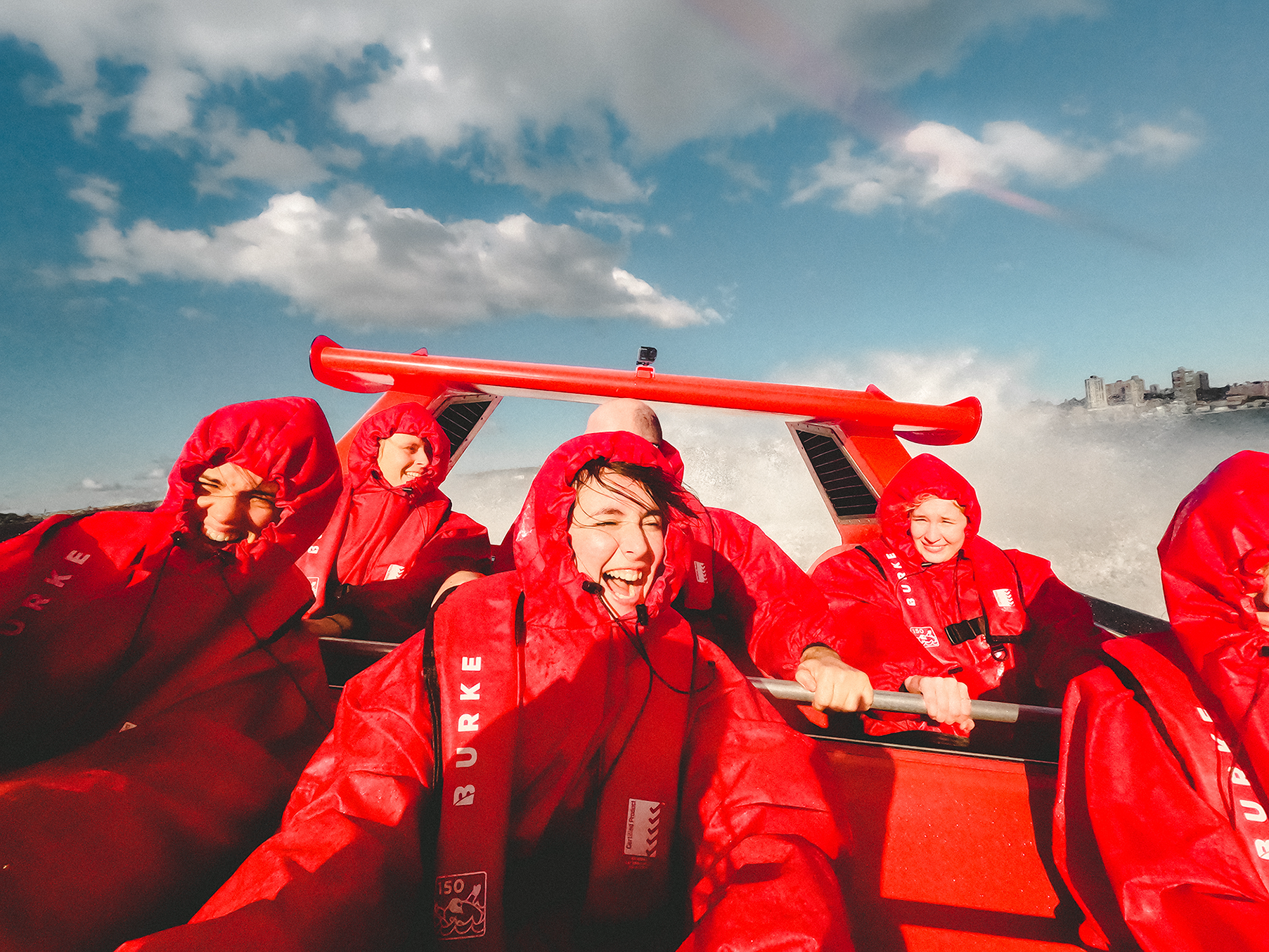 six people riding speedboat near the shore