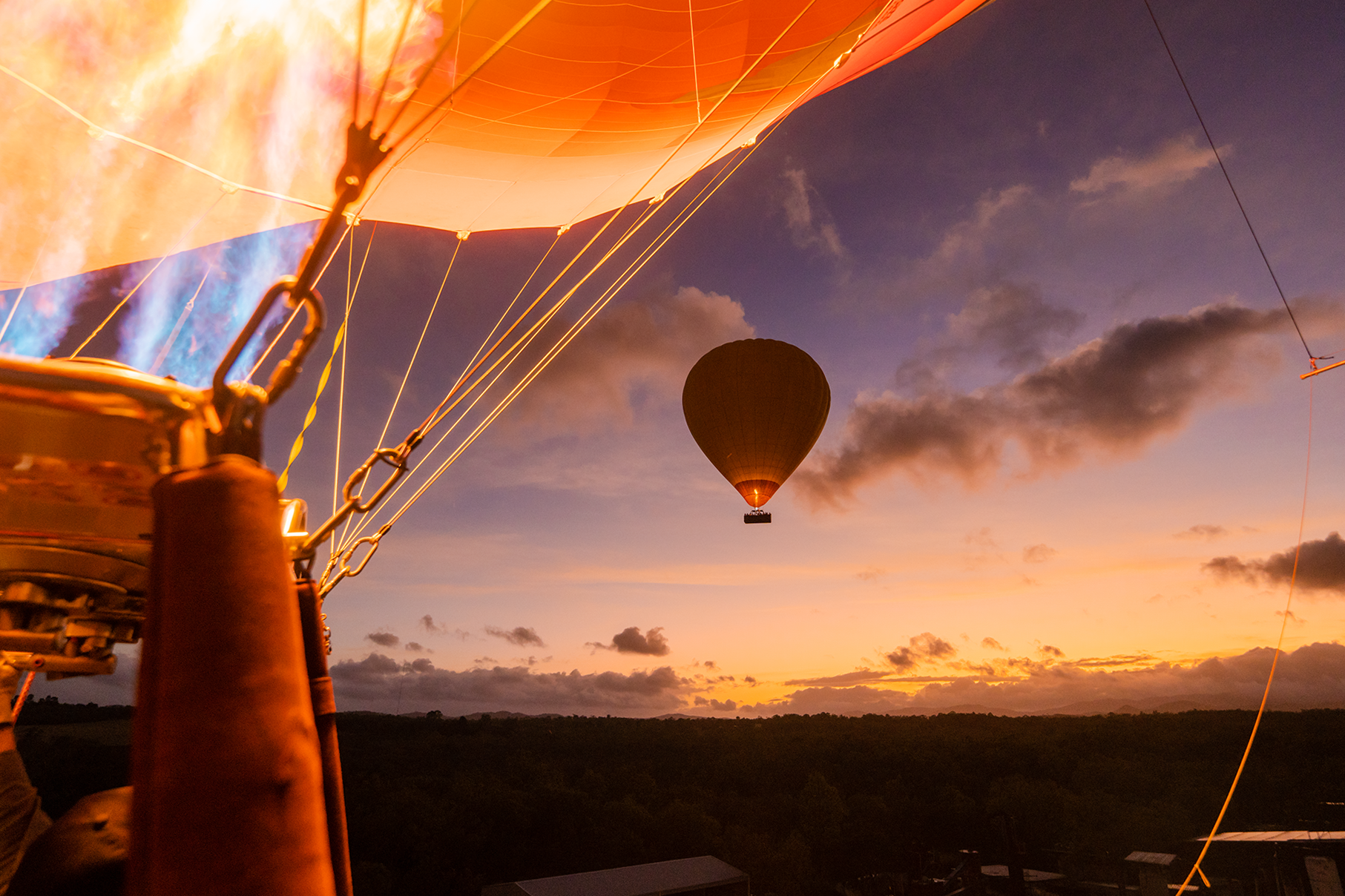 hot air balloon firing up with another balloon in the distance