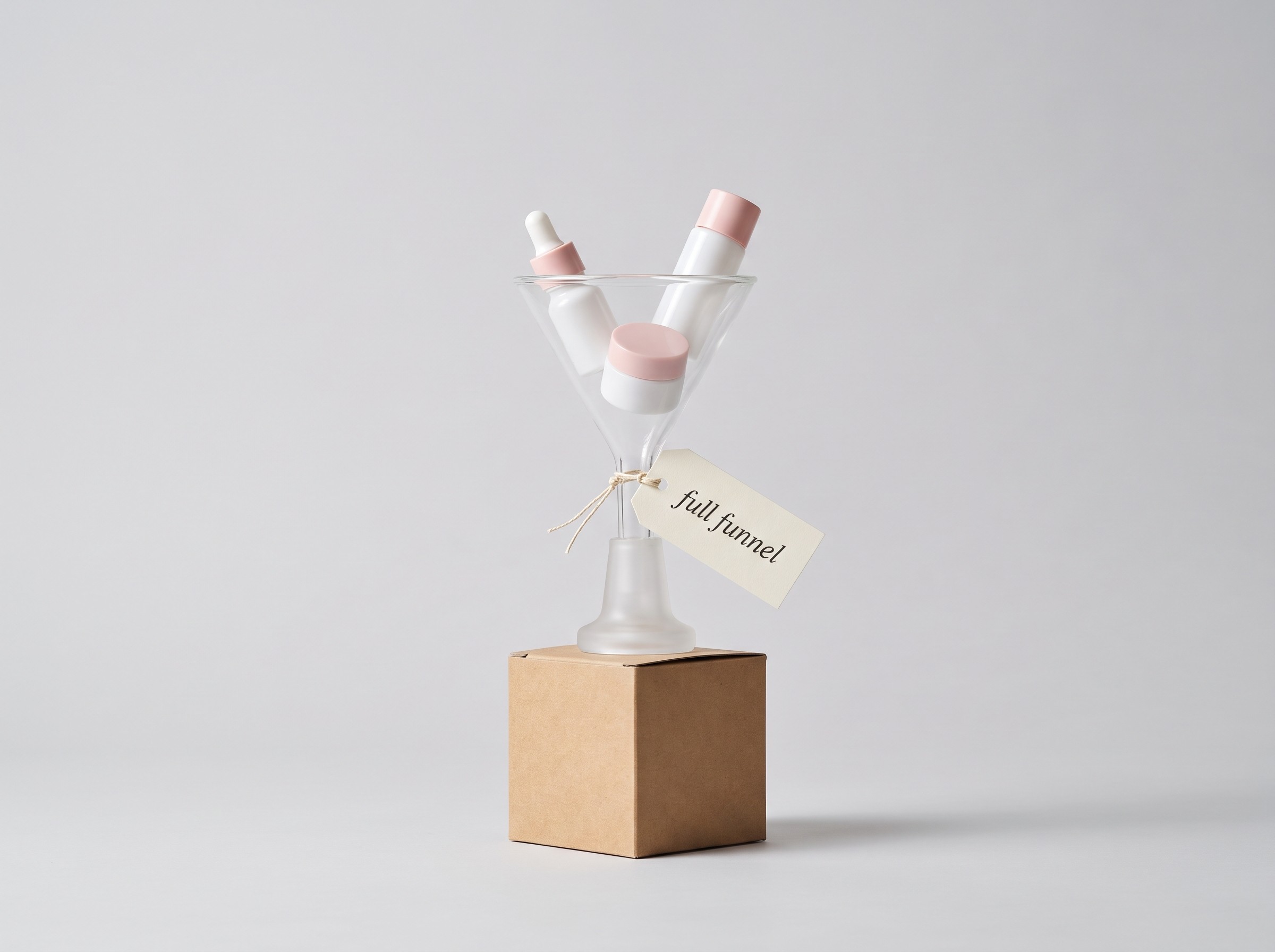 Glass funnel holding Korean skincare bottles above a kraft shipping box, tagged full funnel