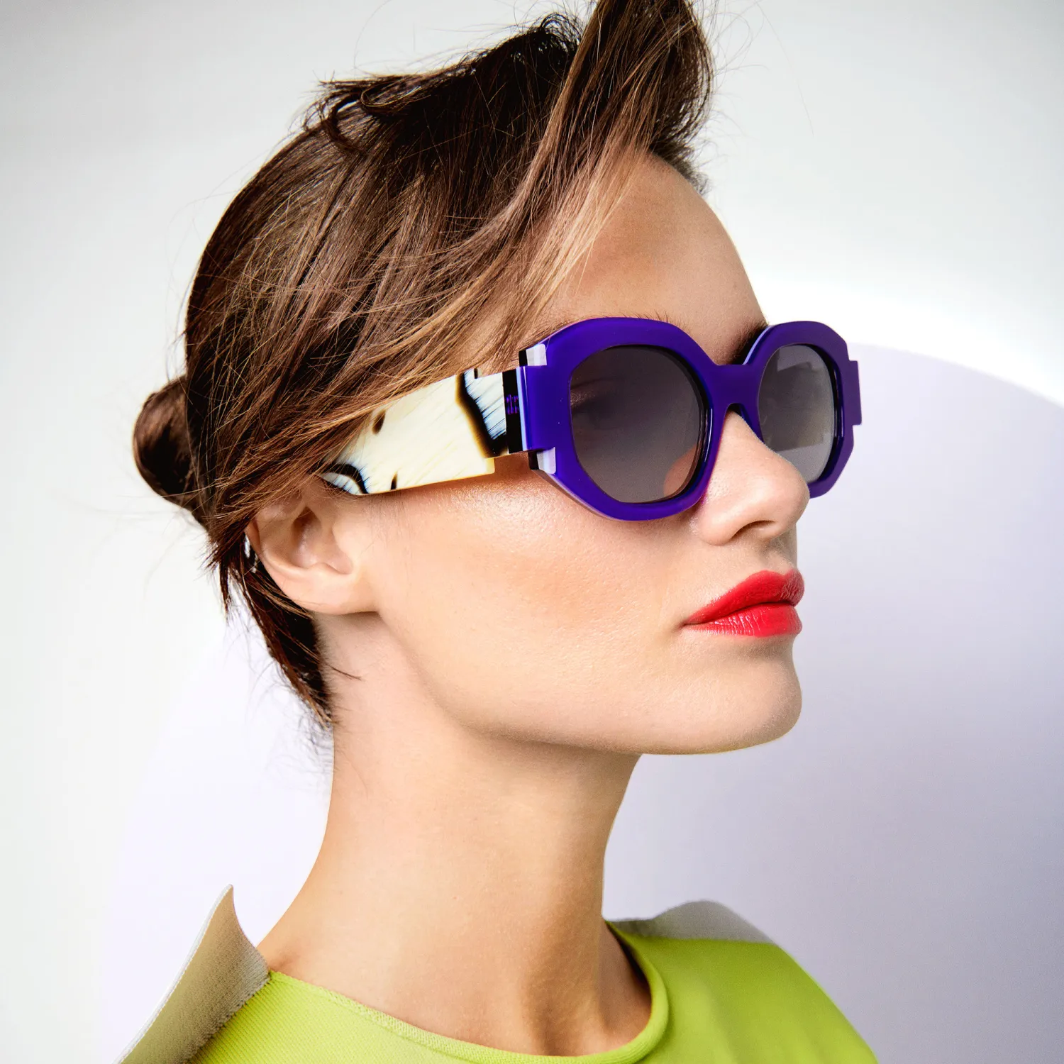 Woman wearing bold purple designer sunglasses showing statement eyewear fashion style