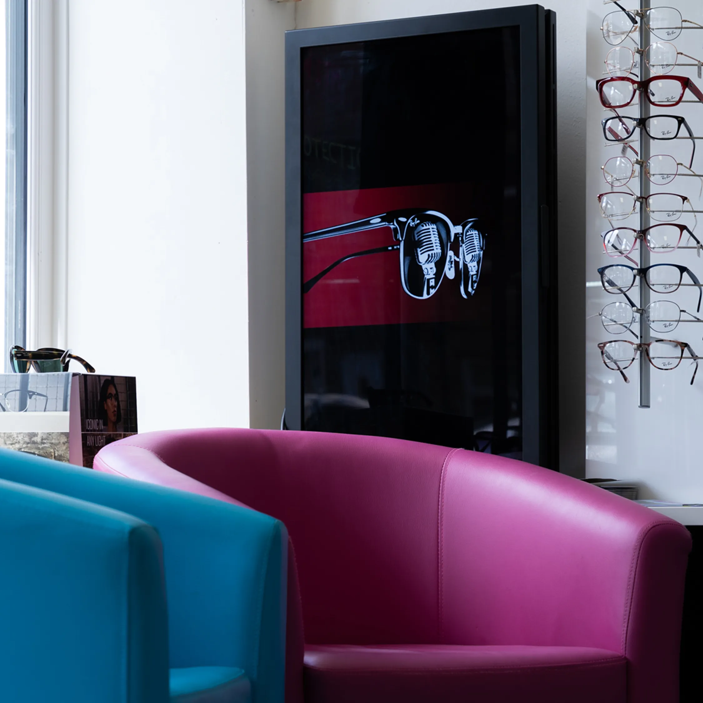 Modern opticians waiting area with colorful seating and designer eyewear display wall