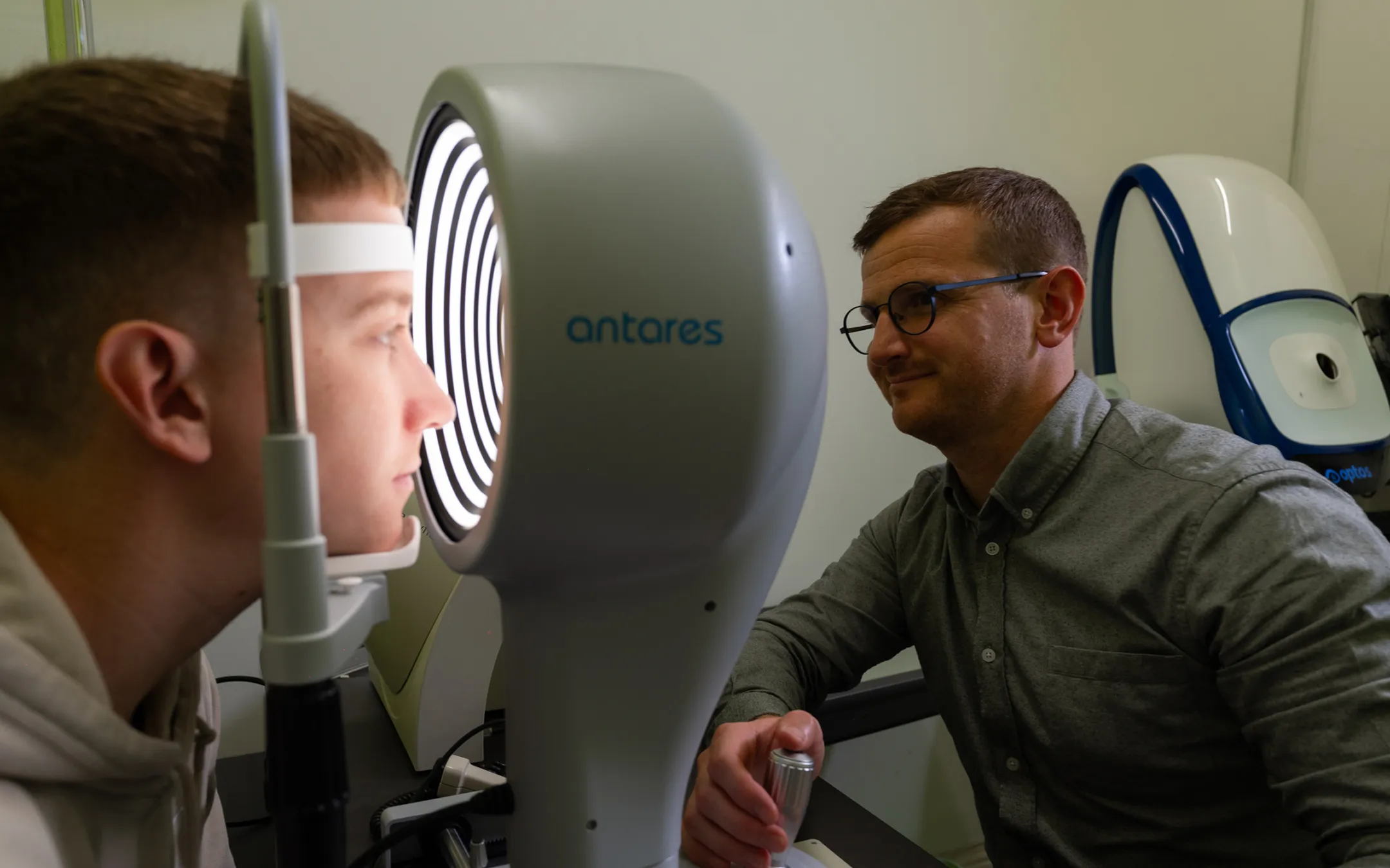 Professional optometrist conducting comprehensive eye examination using advanced optical testing equipment
