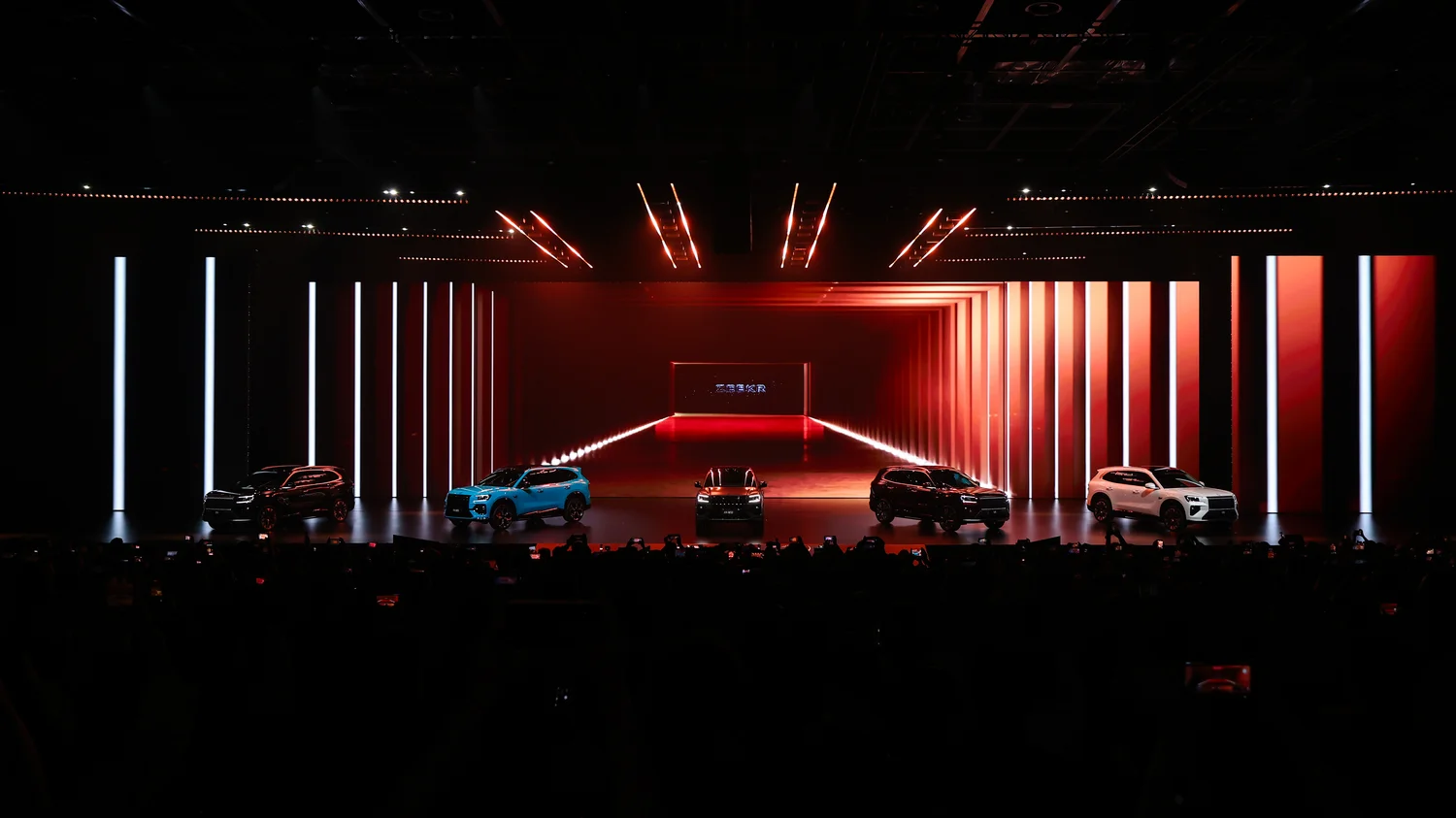 Full ZEEKR 8X launch stage with multiple vehicles and vertical kinetic LED columns creating depth and scale
