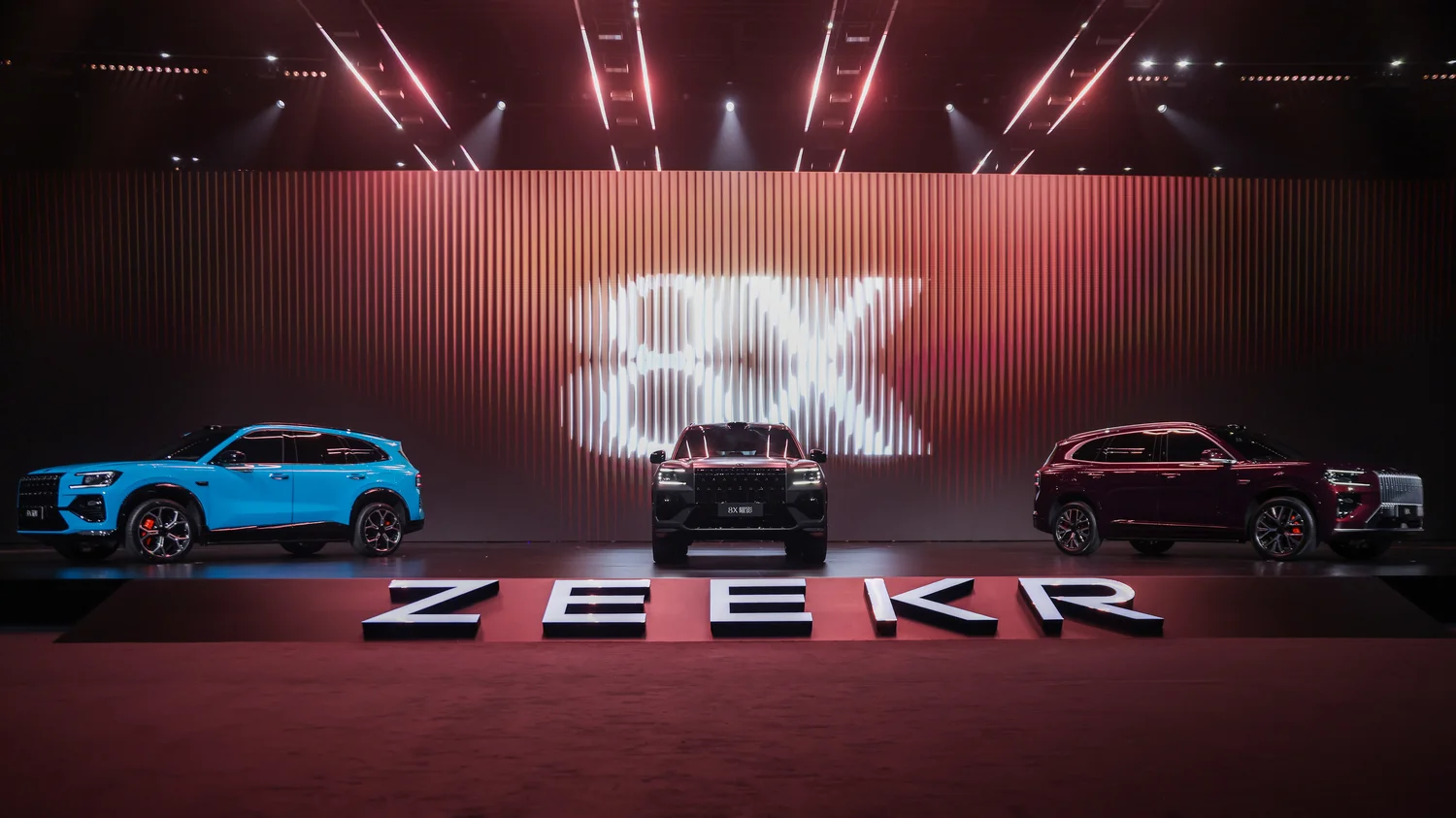 ZEEKR 8X launch event stage with three vehicles and panoramic vertical LED wall displaying kinetic motion content