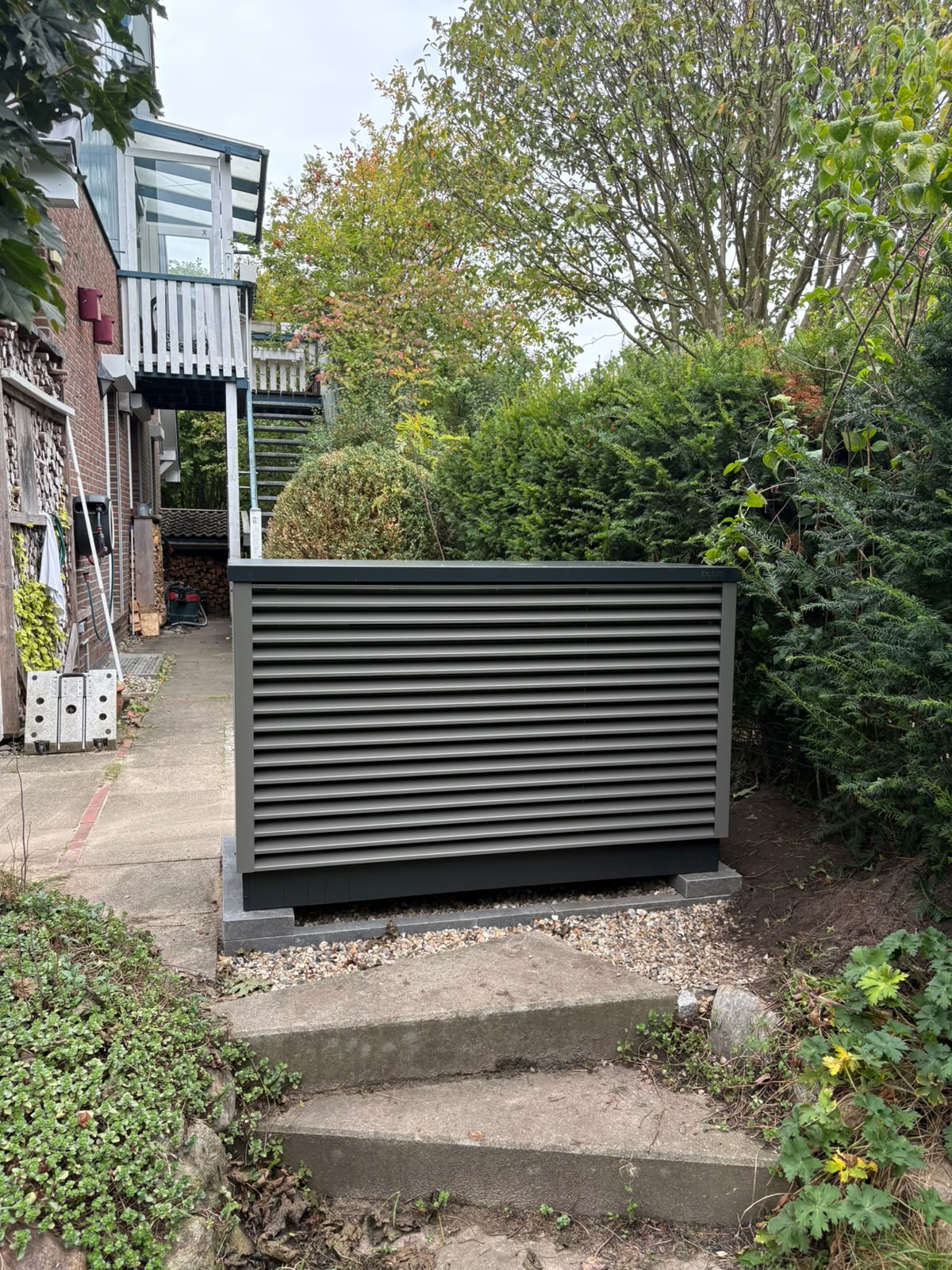 Frontansicht der OVUM Wärmepumpe neben einem Einfamilienhaus in Hamburg