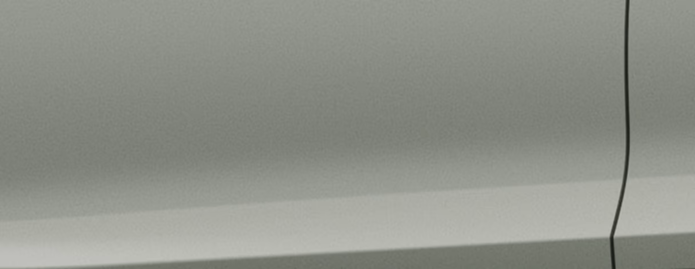 Eine minimalistische Detailaufnahme zeigt einen Ausschnitt der Karosserie des Škoda Fabia Balance in der Lackierung Timiano-Grün. 
