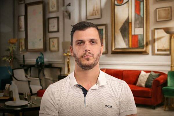 Cozy living room with a red sofa, glass coffee table, beige armchairs, and framed abstract artwork on the wall.
