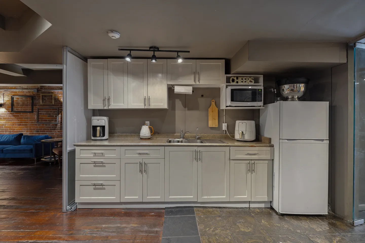 Fully equipped kitchen with white cabinets and tableware at Click Click event venue in Vancouver