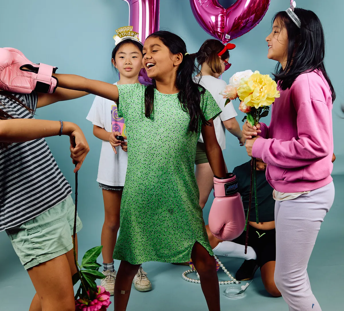 Birthday party guests creating playful self-portraits with studio props
