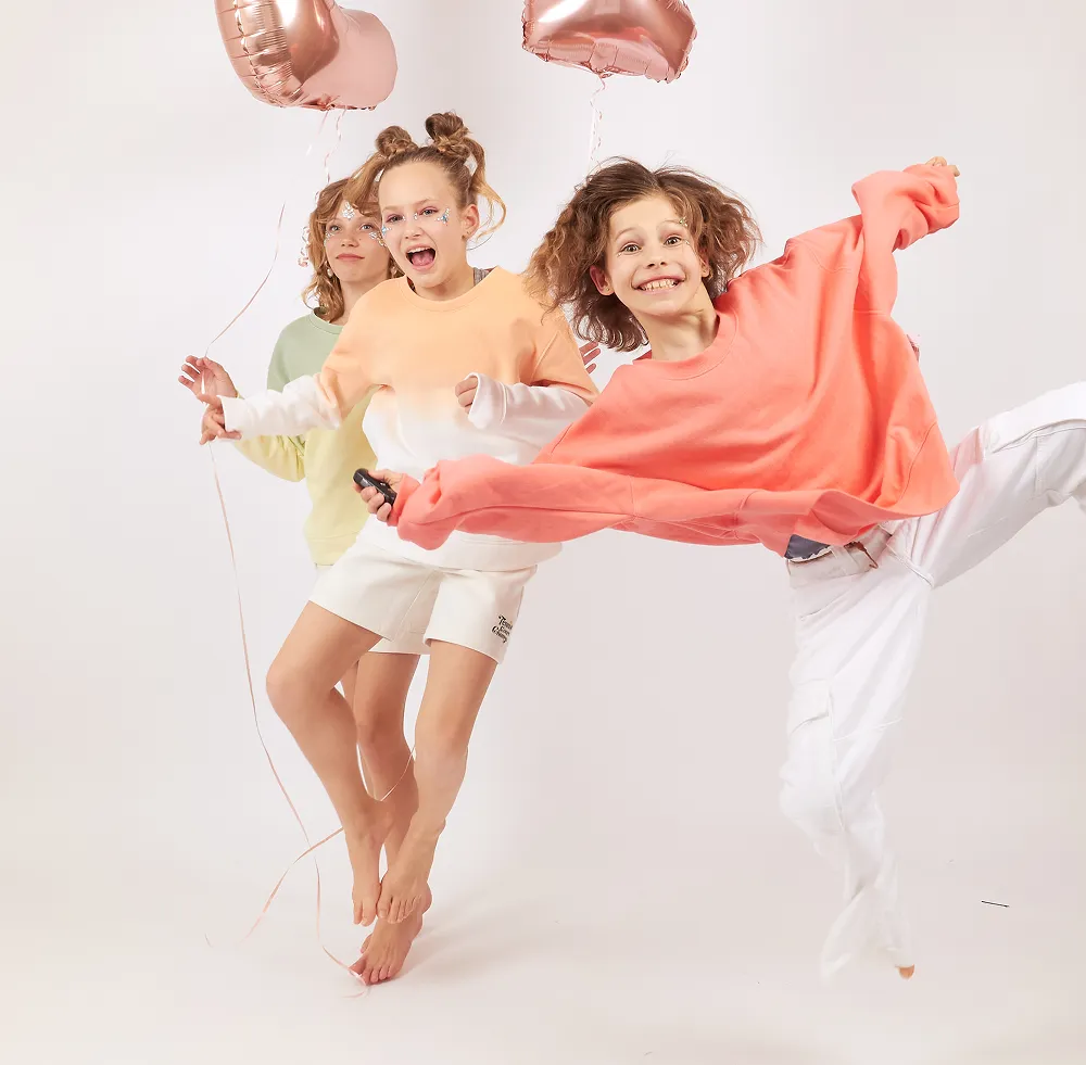 Two children playing with makeup brushes during a birthday celebration