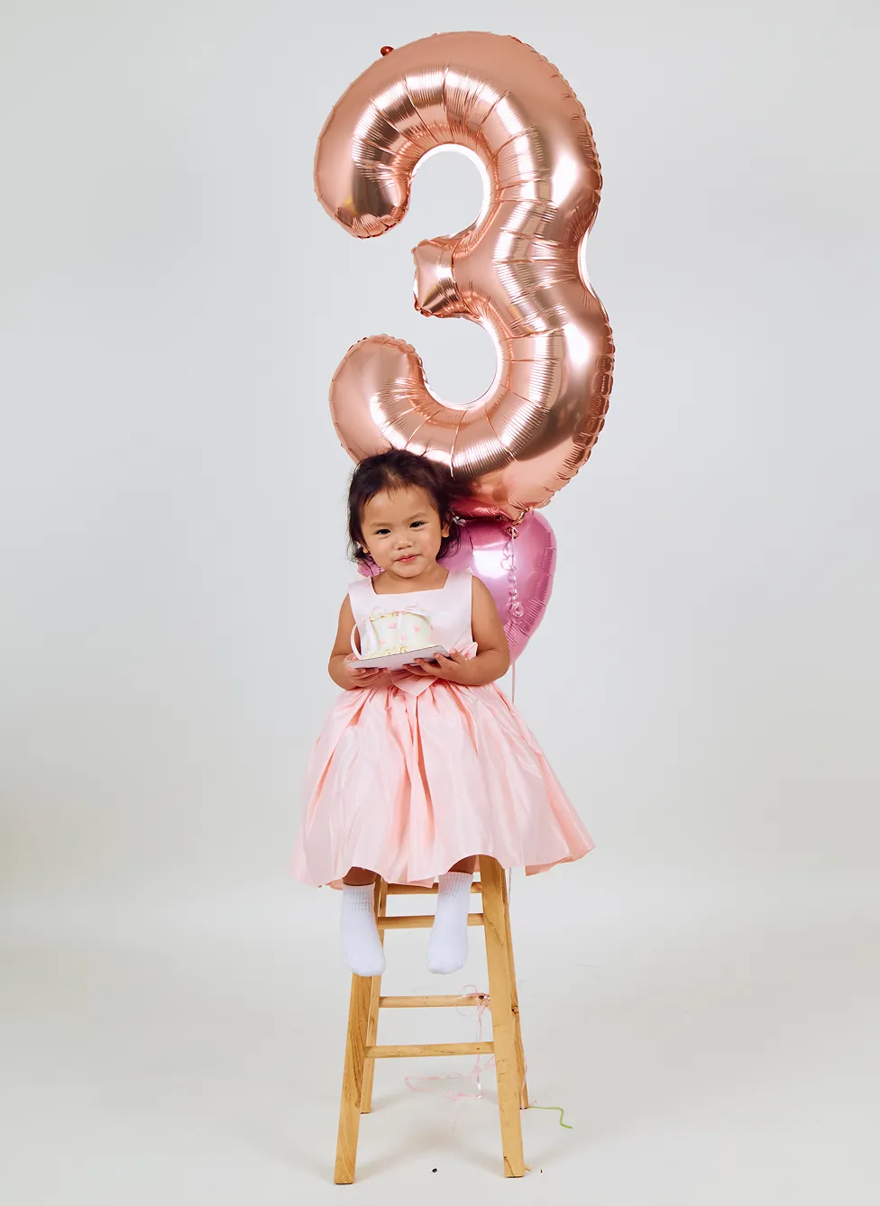 Child posing for a playful birthday portrait at Click Click