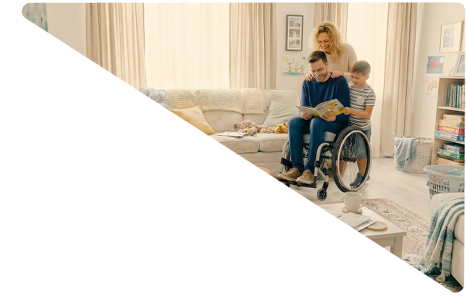 Family in a living room with a man in a wheelchair reading a book to a boy, and a woman standing behind them smiling.