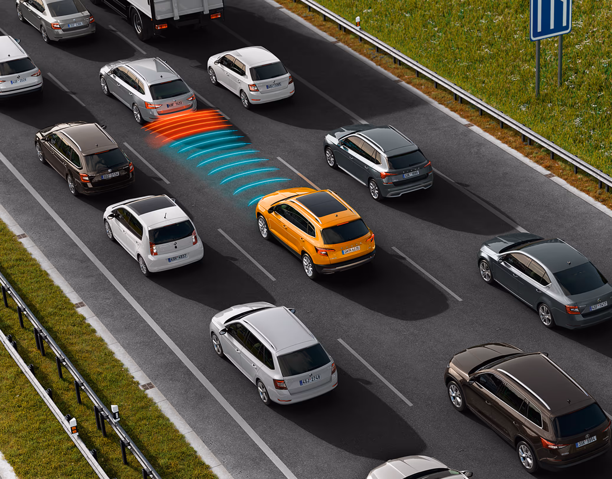 Animation des Stauassistenten: Ein orangefarbener Škoda Karoq Balance im dichten Verkehr auf einer Autobahn. Das Fahrzeug beschleunigt, bremst und lenkt teilautomatisiert und folgt unter Einhaltung der Abstandsregelungen dem Verkehrsfluss.