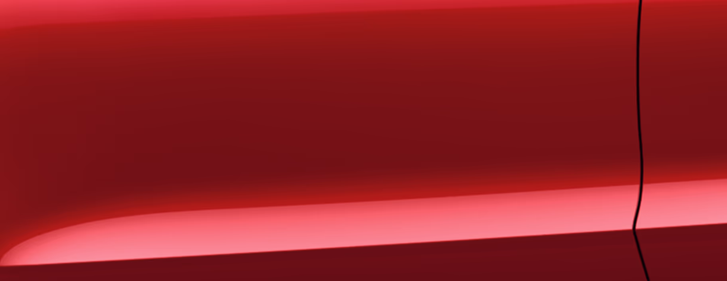 Eine minimalistische Detailaufnahme zeigt einen Ausschnitt der Karosserie des Škoda Karoq Balance in der Lackierung Velvet-Rot Metallic. 
