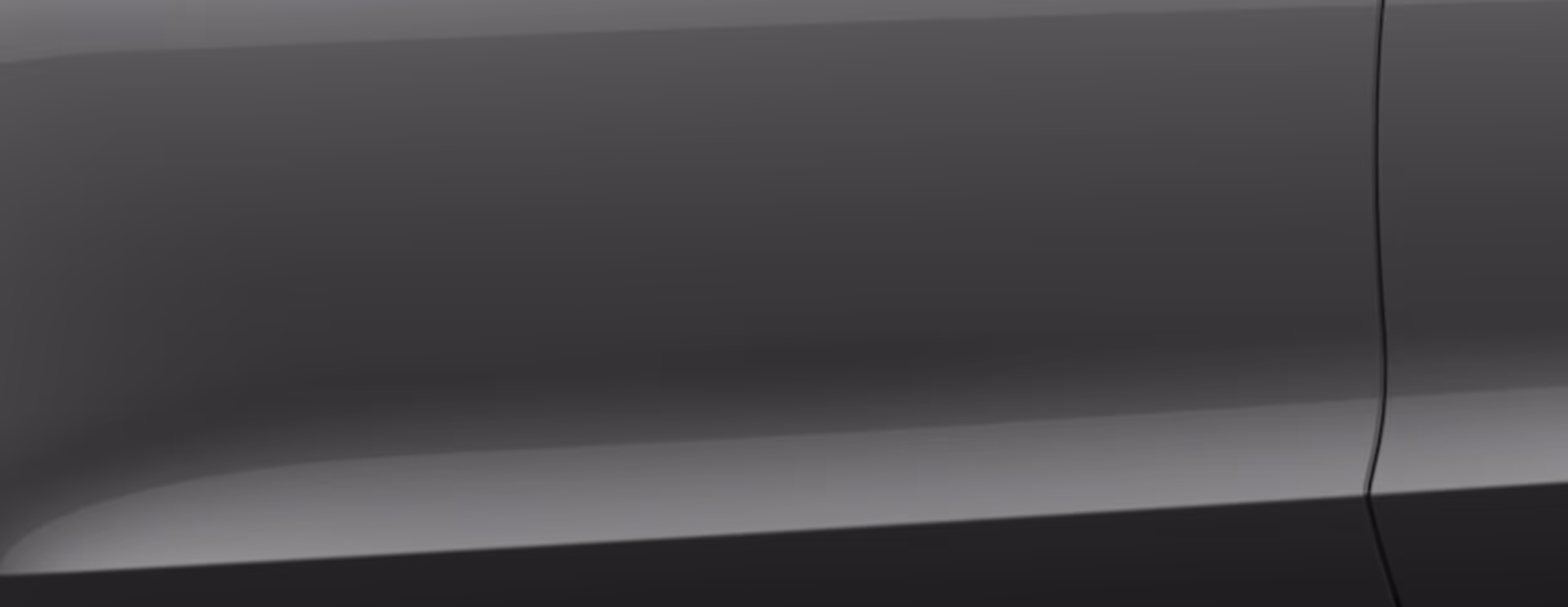 Eine minimalistische Detailaufnahme zeigt einen Ausschnitt der Karosserie des Škoda Karoq Balance in der Lackierung Graphite-Grau Metallic. 
