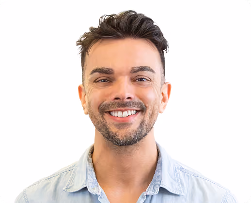 Portrait d'un homme souriant avec une barbe courte et des cheveux foncés coiffés, portant une chemise en denim clair sur fond blanc.