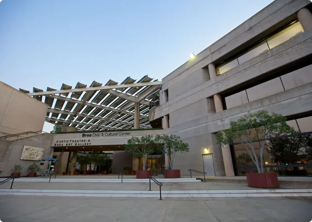 Entrance of Brea Civic & Cultural Center with Curtis Theatre and Brea Art Gallery under a large solar panel canopy.