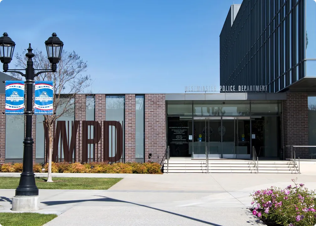 Modern Westminster Police Department building with large WPD letters and entrance steps under clear blue sky.