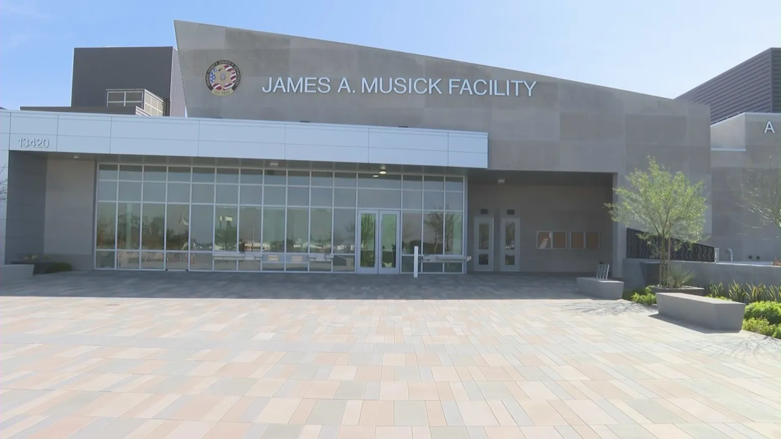 Modern entrance of the James A. Musick Facility with large windows and a tiled courtyard.