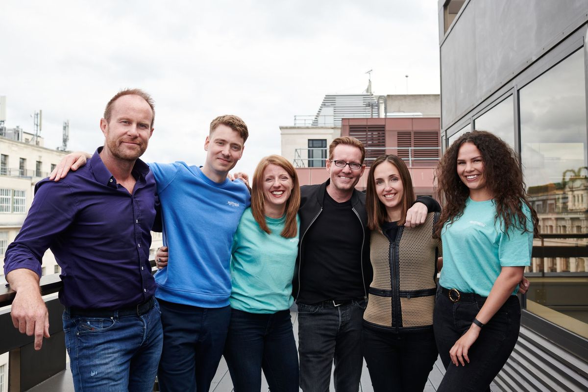 A group of people posing for a picture on a balcony