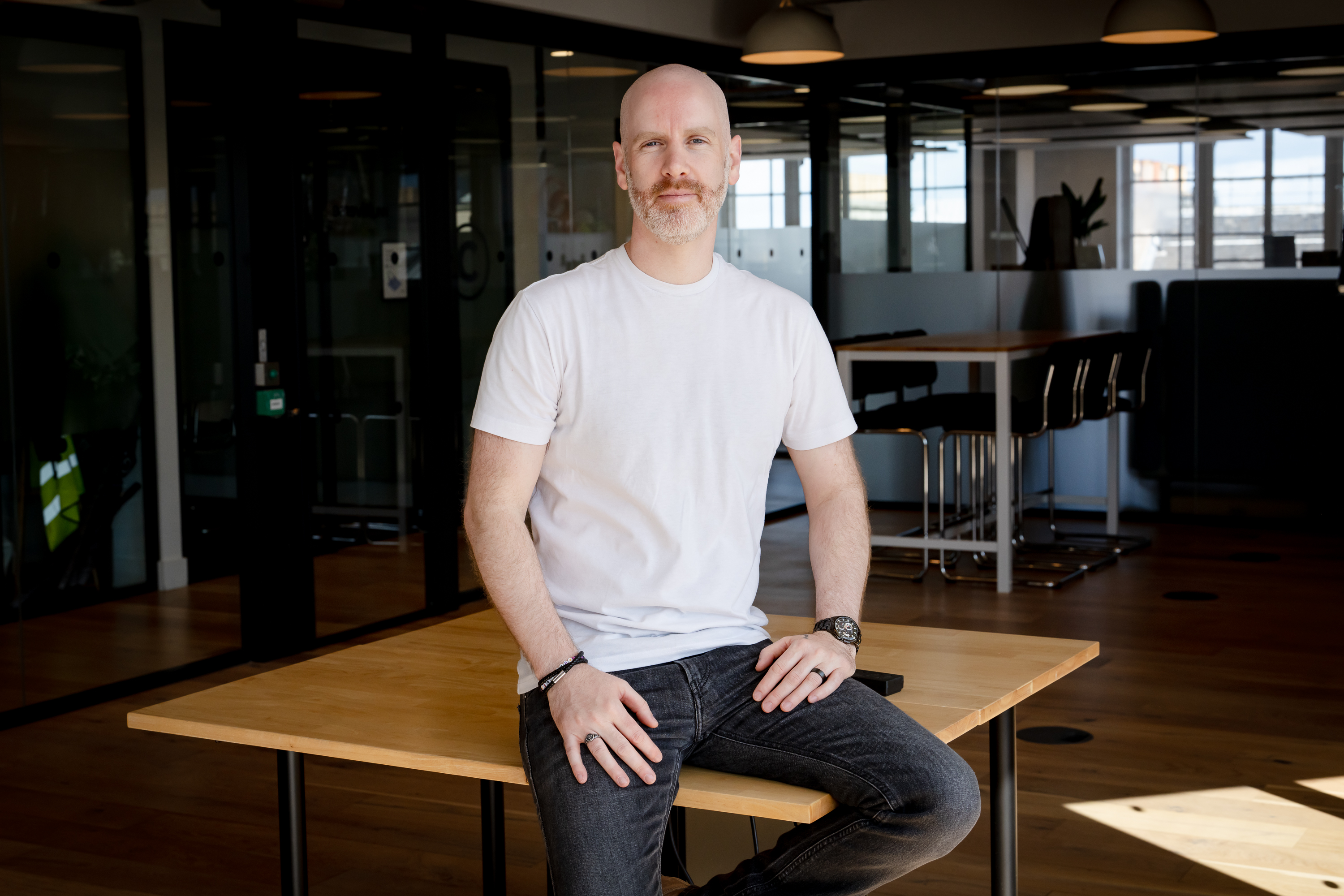 Image of Colin Mackenzie, Multiverse's VP AI engineering, sat on a desk in Multiverse's Edinburgh office