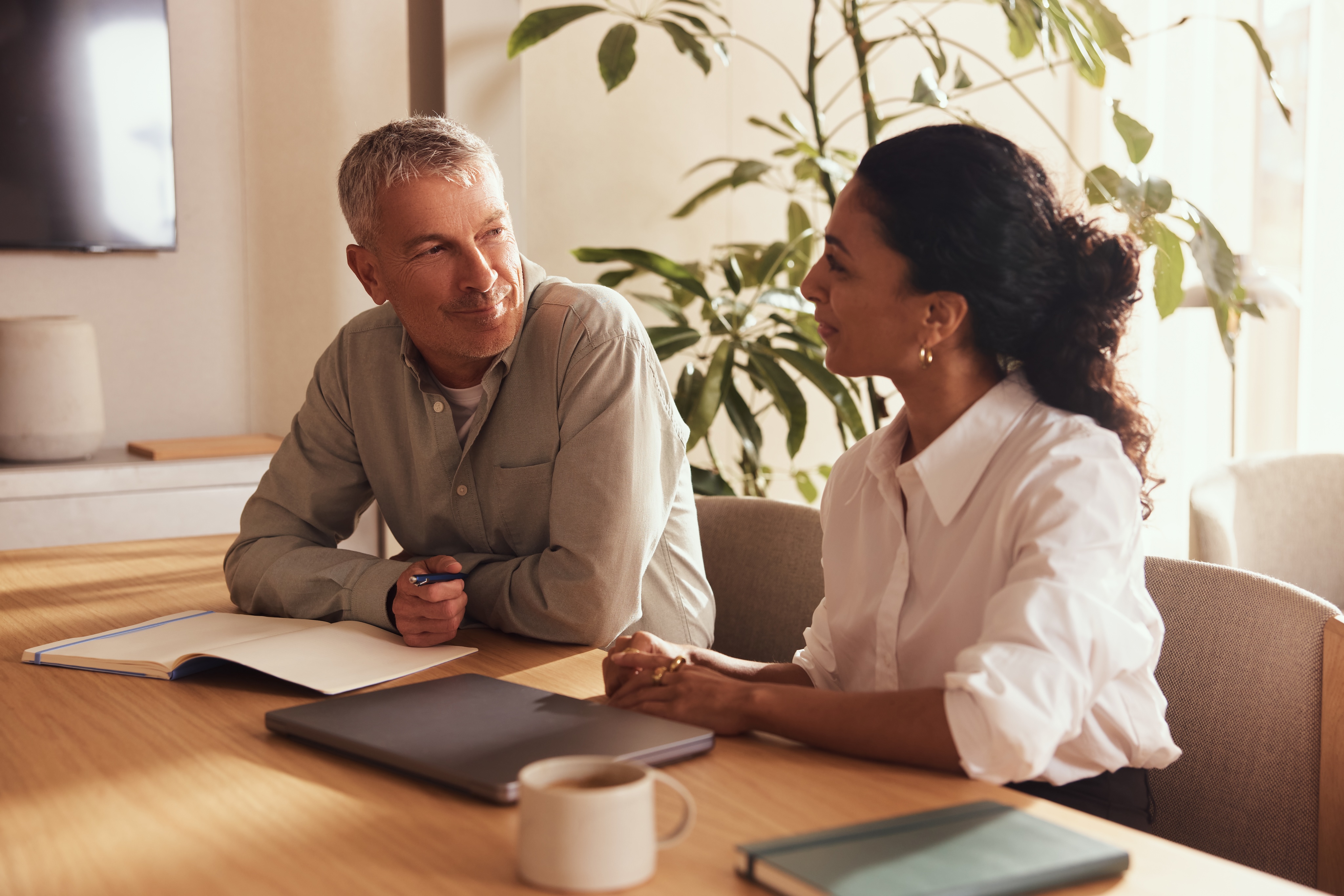 A Multiverse coach and learner talking together at a table during a coaching session