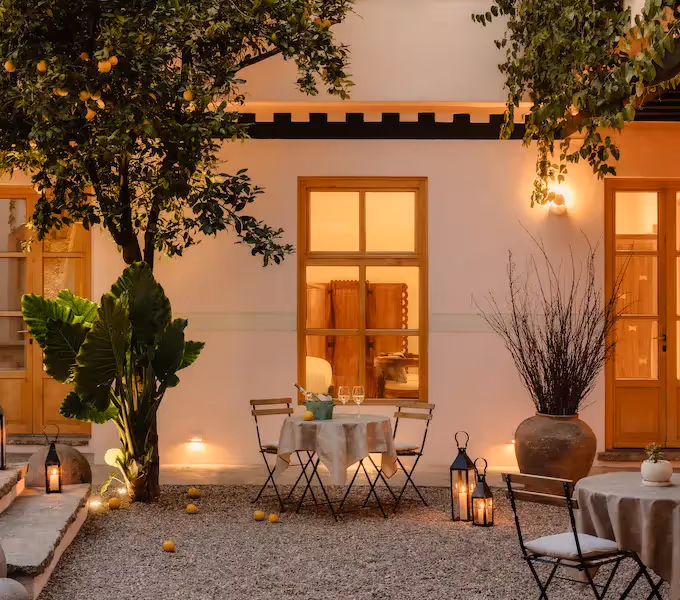 El lujoso patio del hotel La Valise San Miguel cuenta con una piscina iluminada, escaleras de piedra y arquitectura colonial al anochecer.