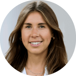 Portret van een jong vrouwelijk met lang bruin haar, glimlachend en kijkend naar de camera.