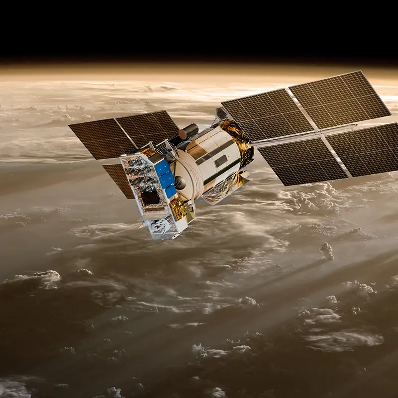 Satellite equipped with large solar panels orbiting above a planet with visible cloud formations and atmospheric layers.
