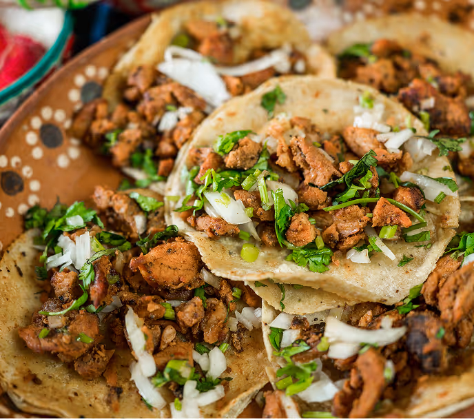 Golfer in white cap and shirt swinging club on a green golf course.