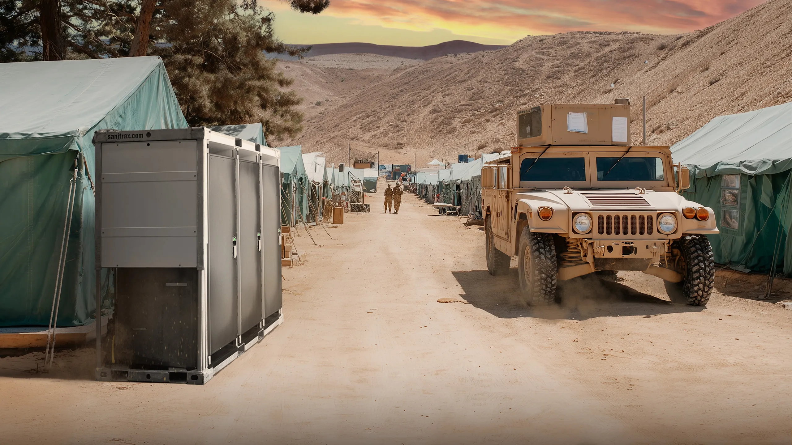 Gray portable sanitation unit outside military tents with tan military vehicle on dirt road