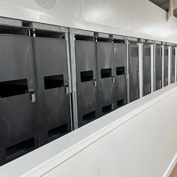 Row of black wall-mounted hand sanitizer dispensers inside building