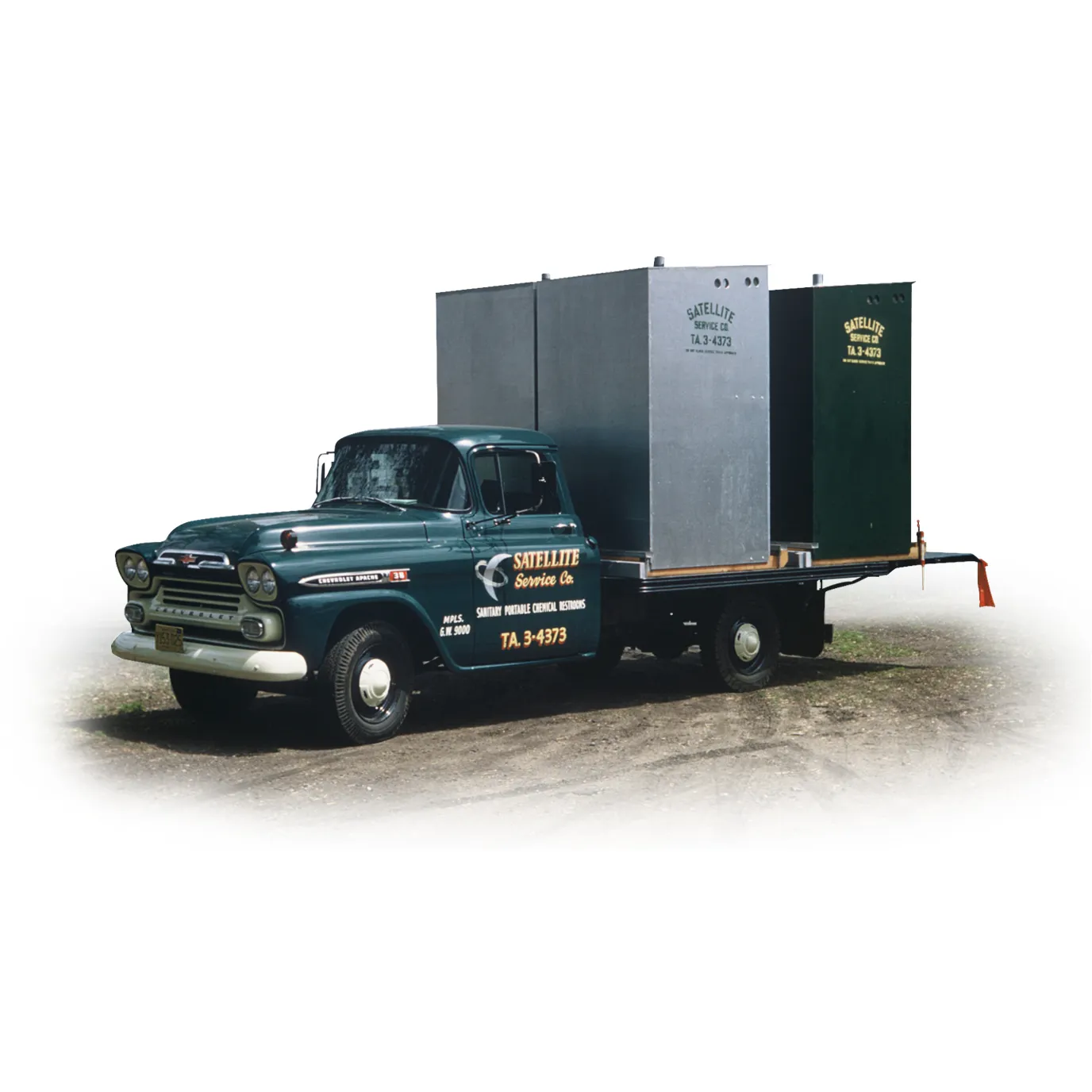 Vintage dark green Chevrolet truck with two portable restrooms on flatbed, labeled Satellite Service Co.